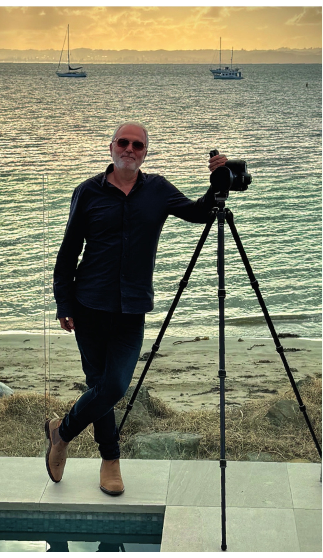 John Williams, KBQ New Zealand Editor and Photographer, with his camera beside the sea